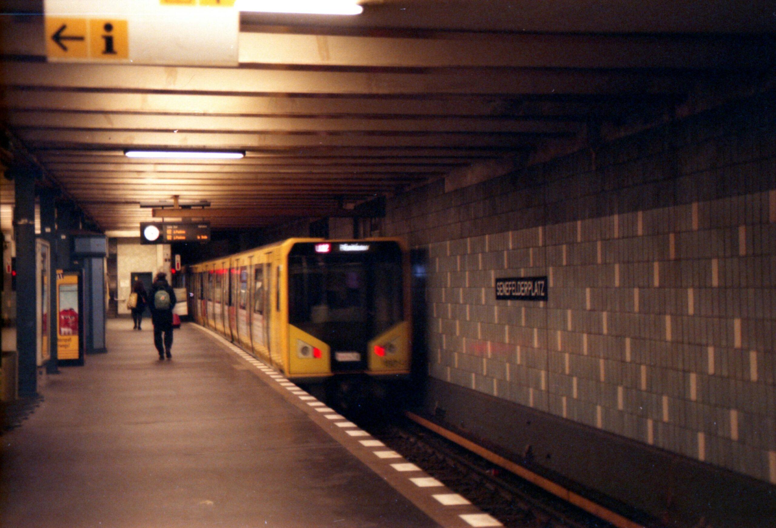Yellow train arriving at Seestrasse metro station in Berlin with platform view.