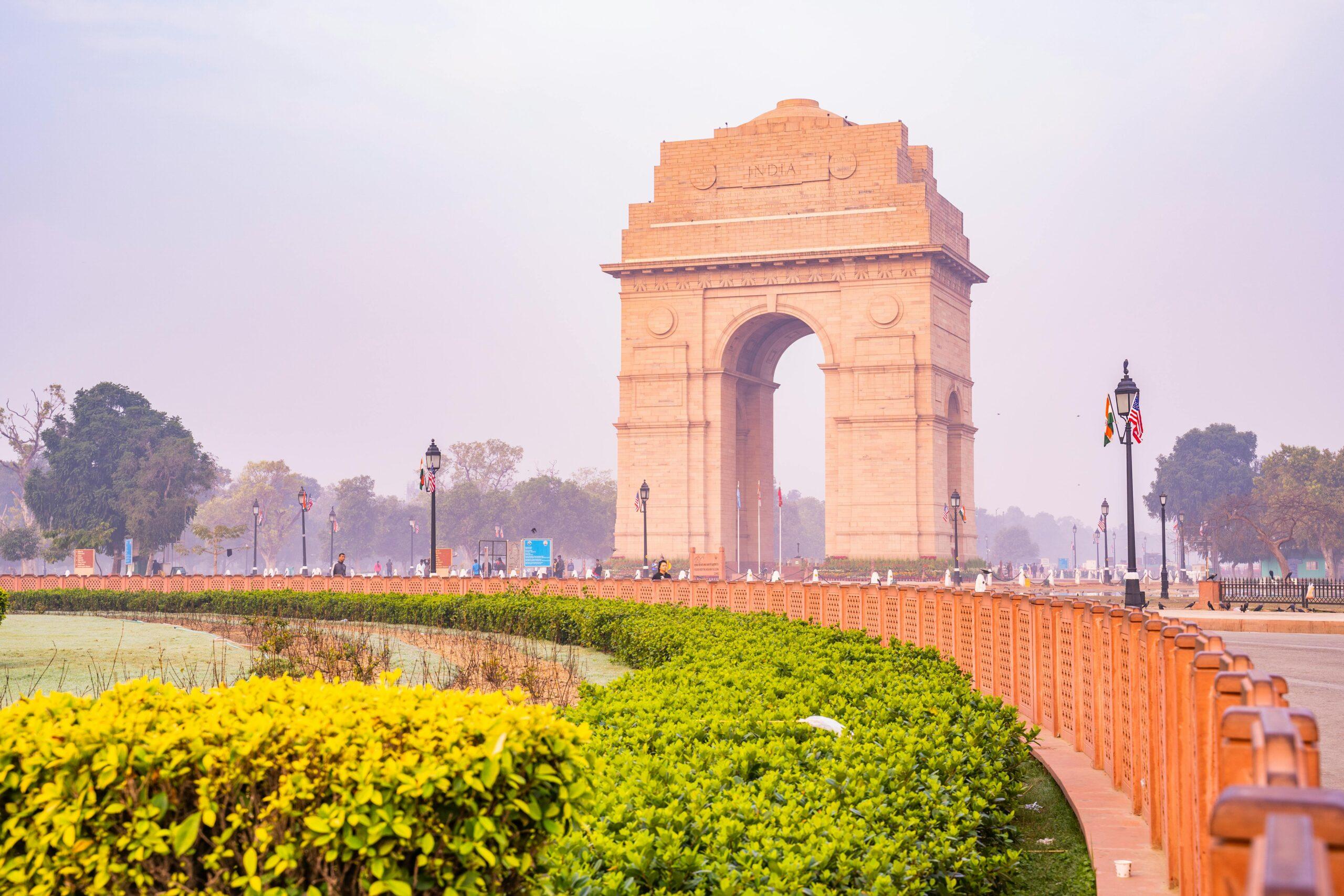 A vibrant capture of the iconic India Gate in New Delhi, surrounded by lush gardens on a sunny day, showcasing its architectural brilliance.